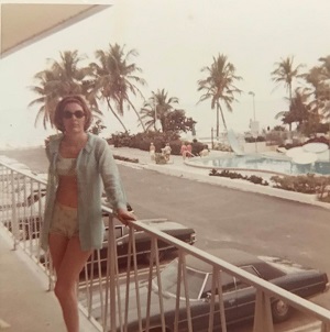 Granny in the 80s, leaning against a hotel balcony overlooking Cadillacs and palm trees.